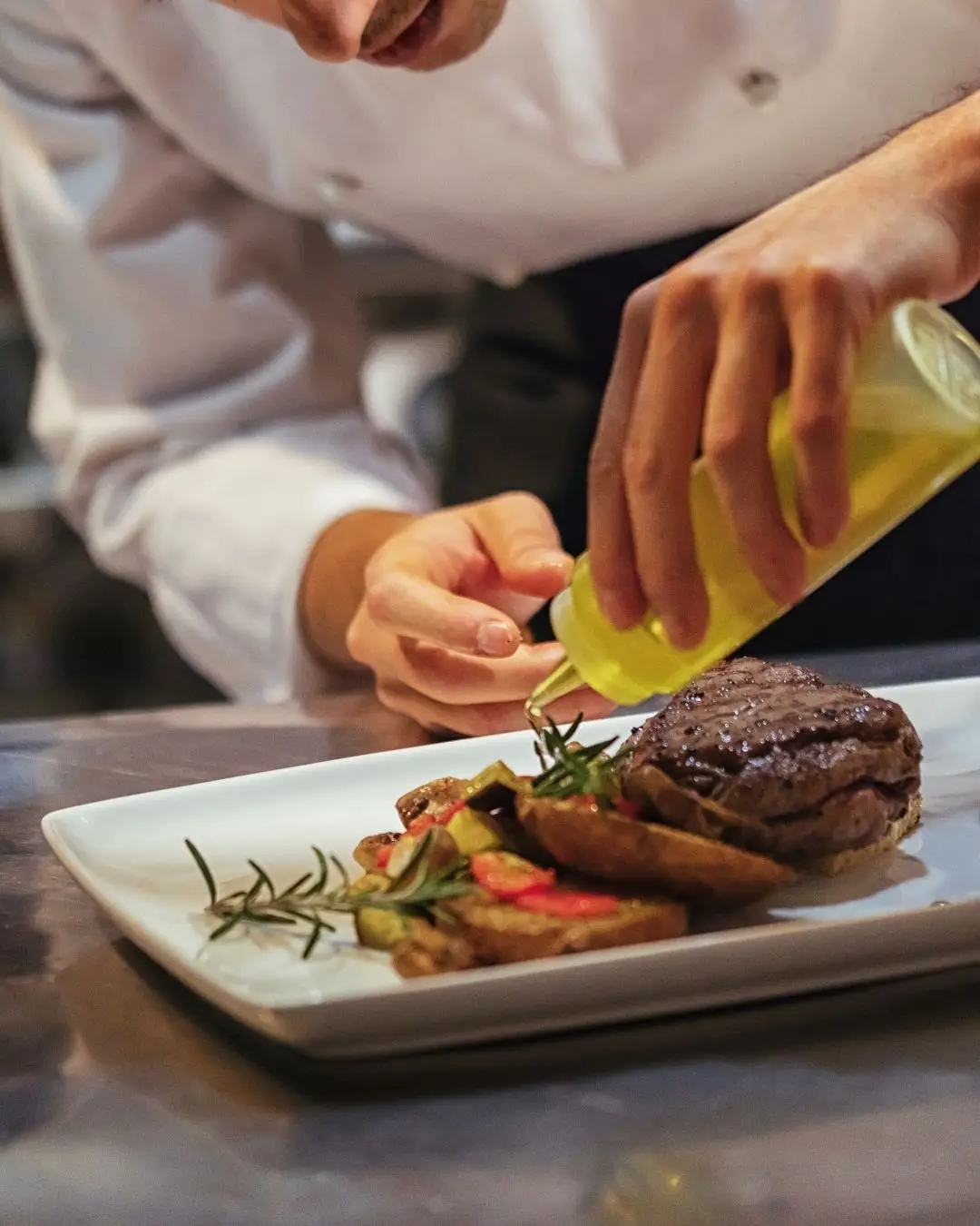 propietaria sonriente en la entrada de su restaurante local en españa, apoyada por mobilcity, mostrando ambiente auténtico y acogedor